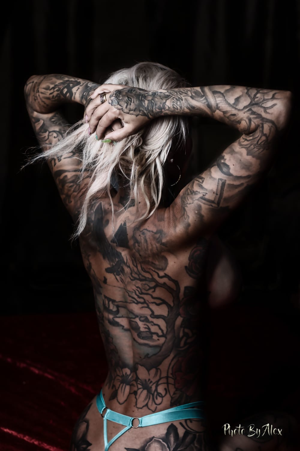 En bild på NinaSwedens tatuerade rygg naken sittandes.